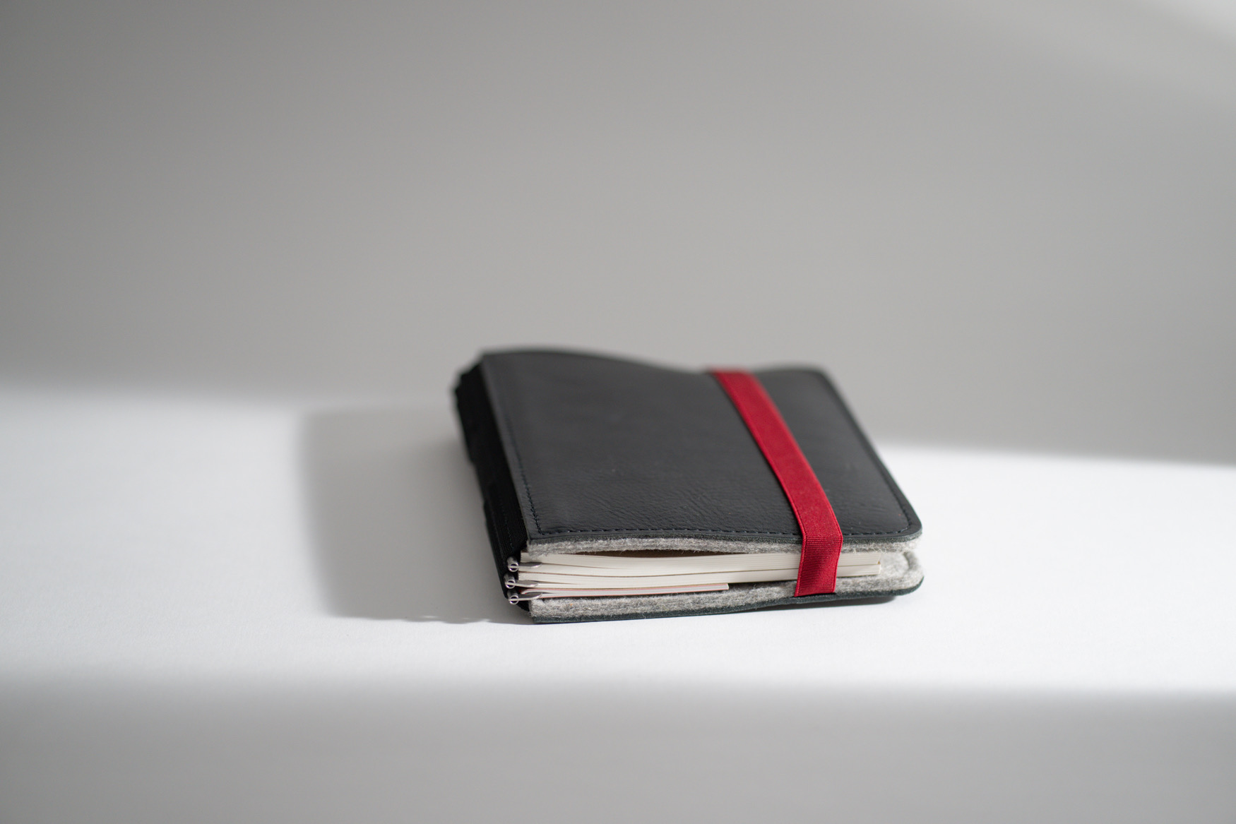 ROTERFADEN Taschenbegleiter LTD_022 in M-Format aus nachhaltigem Rindleder und Merinowollfilz. Vielseitig mit 3 Klammerpaaren für Hefte und Tablets.