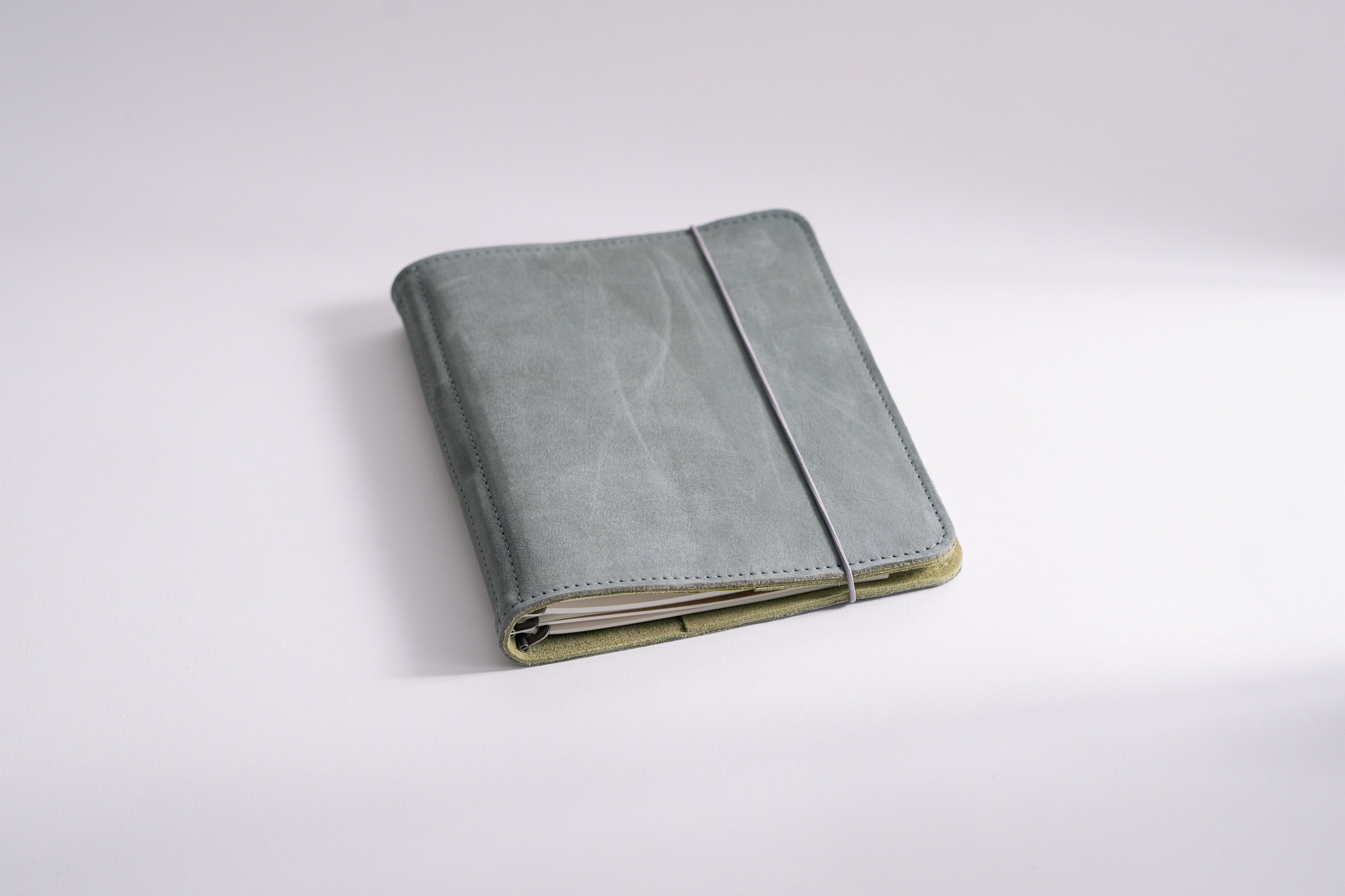 Taschenbegleiter ST_17 mit pflanzlich gegerbtem grauem Antikleder und chromfrei gegerbtem Veloursleder innen mit austauschbarem Verschlussgummi. 