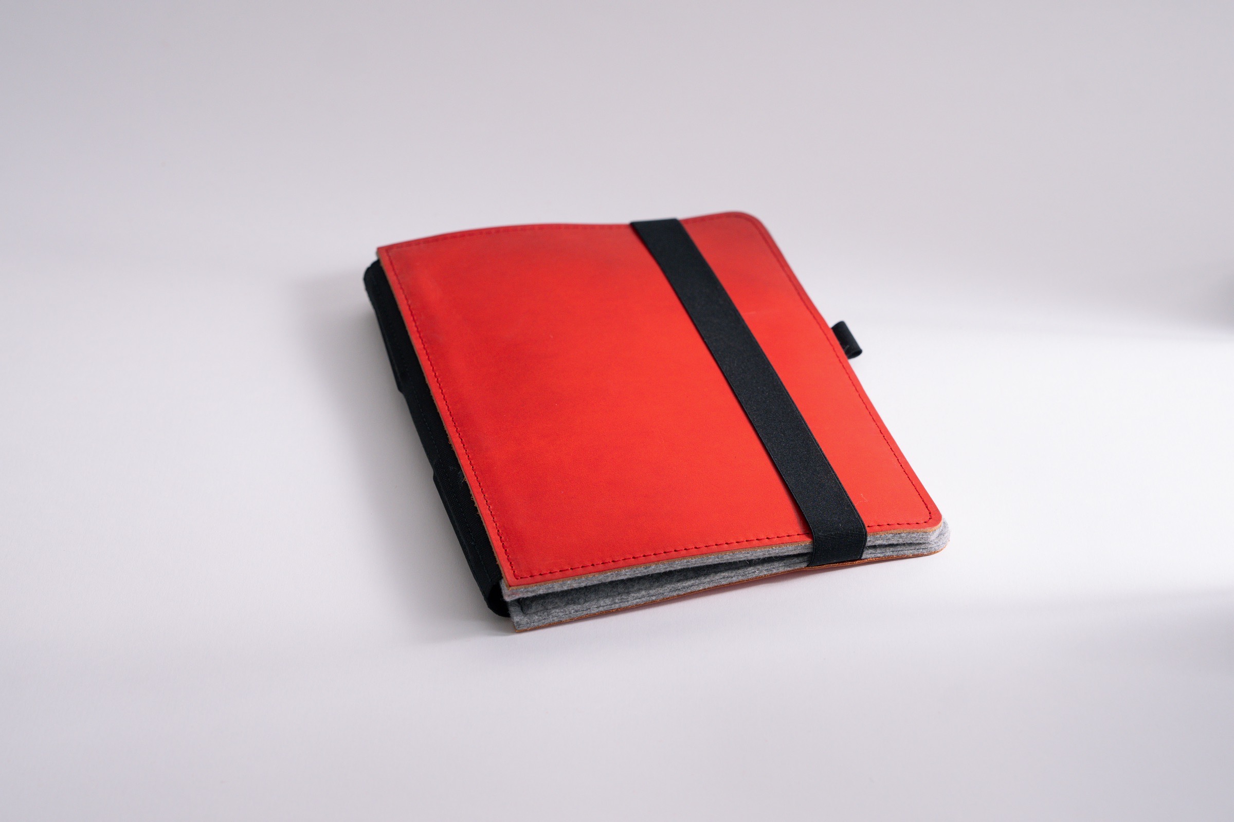 Taschenbegleiter LTD_028 in light gray felt inside and red felt outside, with inwardly offset clips to hold your notebooks an papers.
