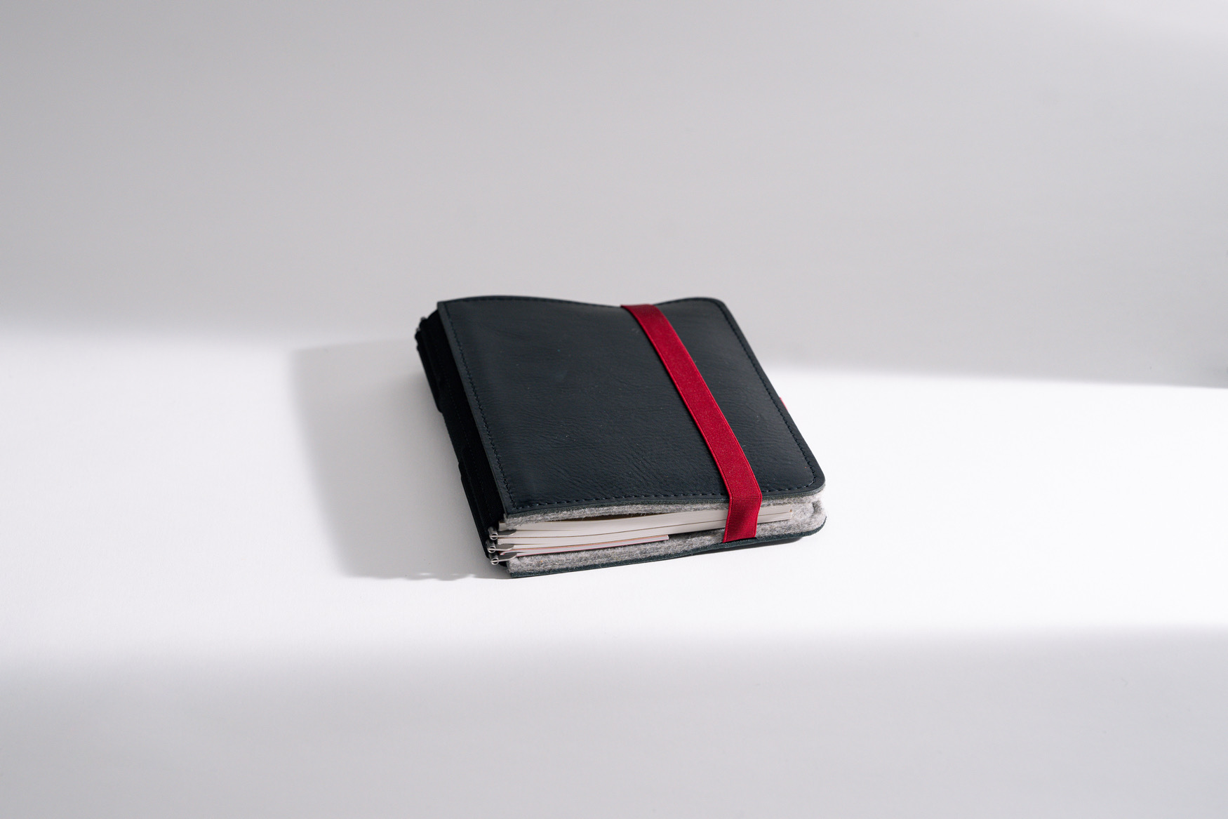 ROTERFADEN Taschenbegleiter LTD_022 in M-Format aus nachhaltigem Rindleder und Merinowollfilz. Vielseitig mit 3 Klammerpaaren für Hefte und Tablets.